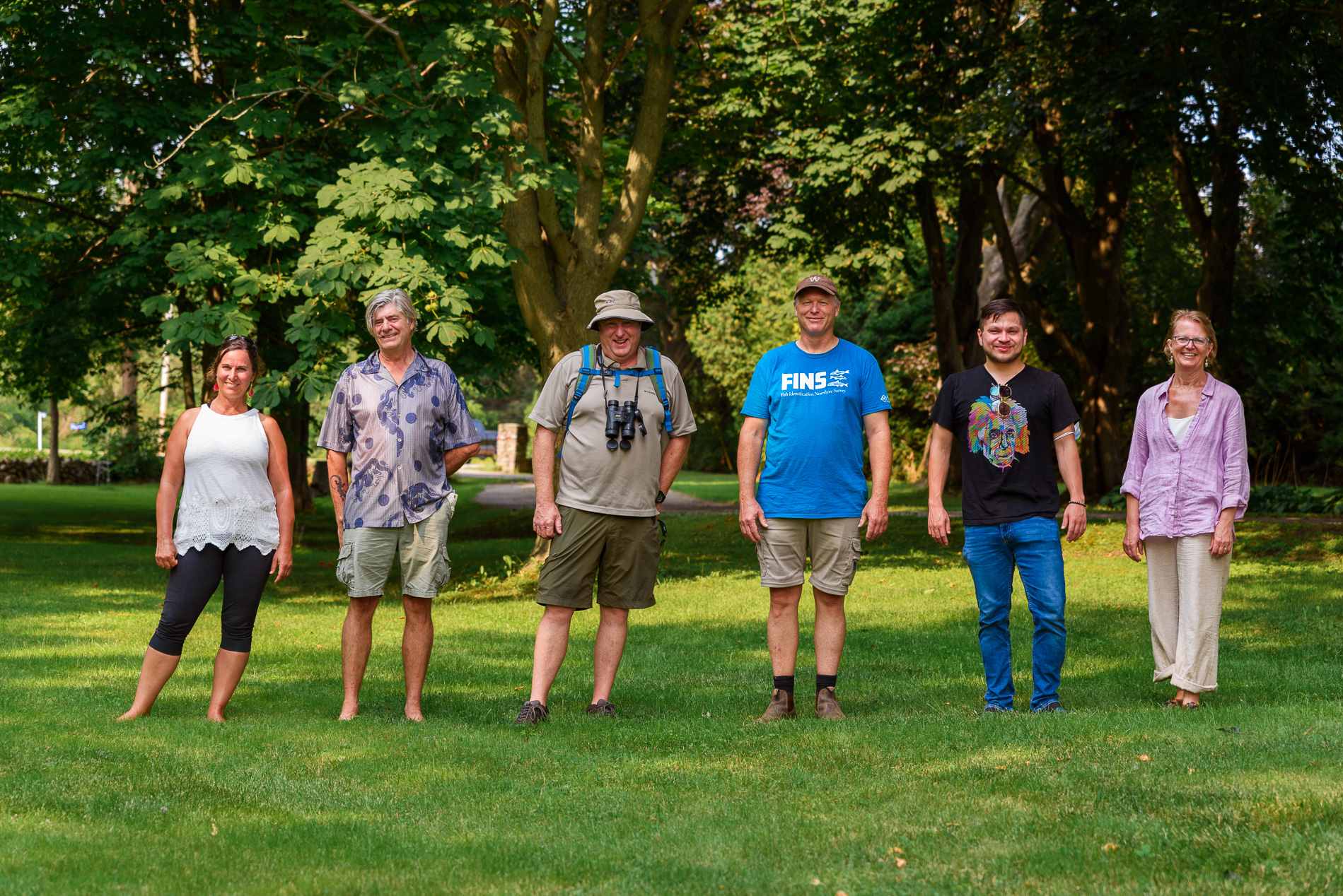 Four people standing in a row of a garden - Climate Action